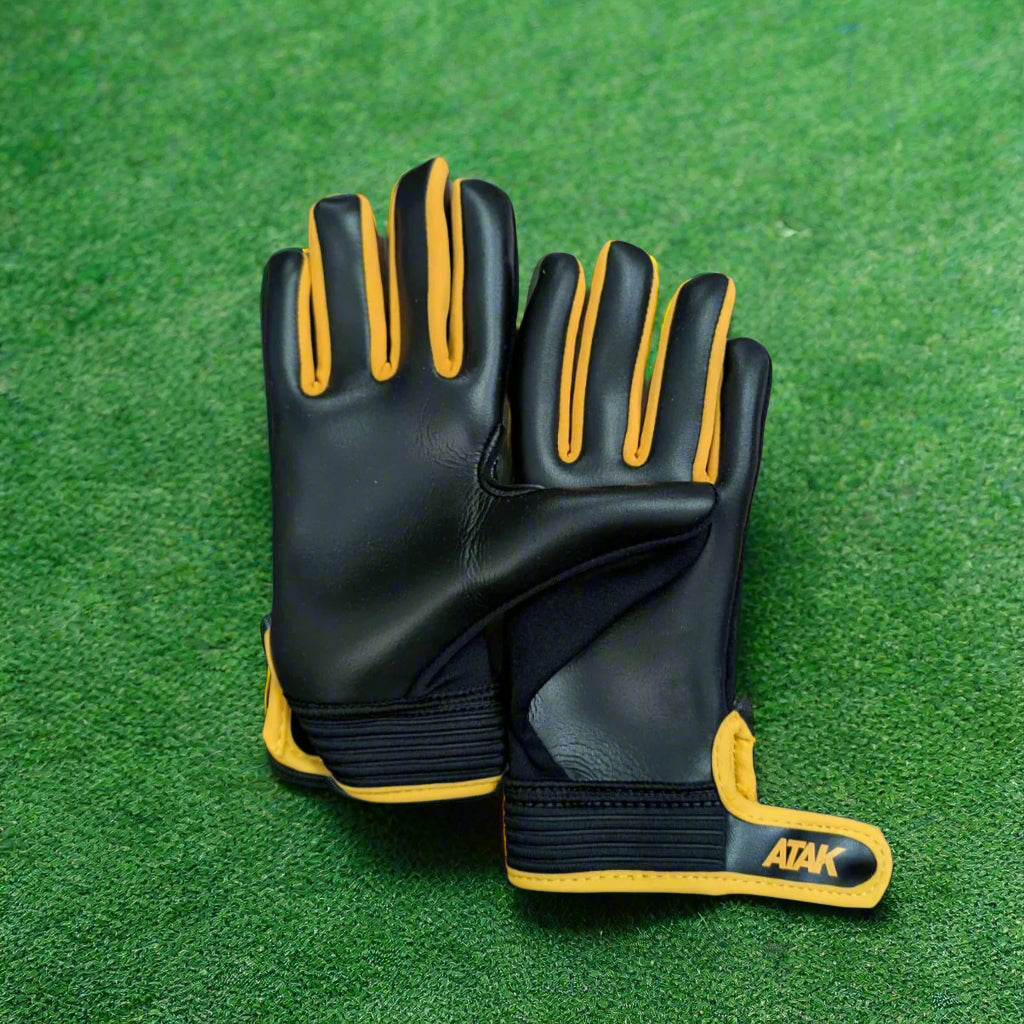 Black and amber ATAK air gloves on a green grass background
