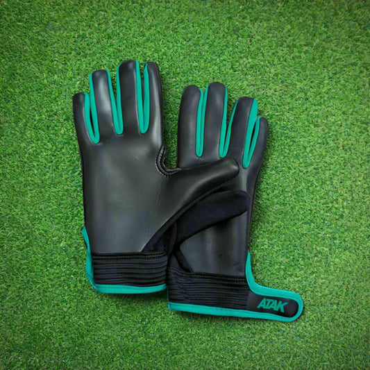 Black and green ATAK air gloves on a green grass background