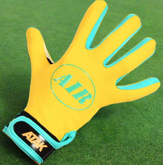 Yellow ATAK air gloves on a green grass background