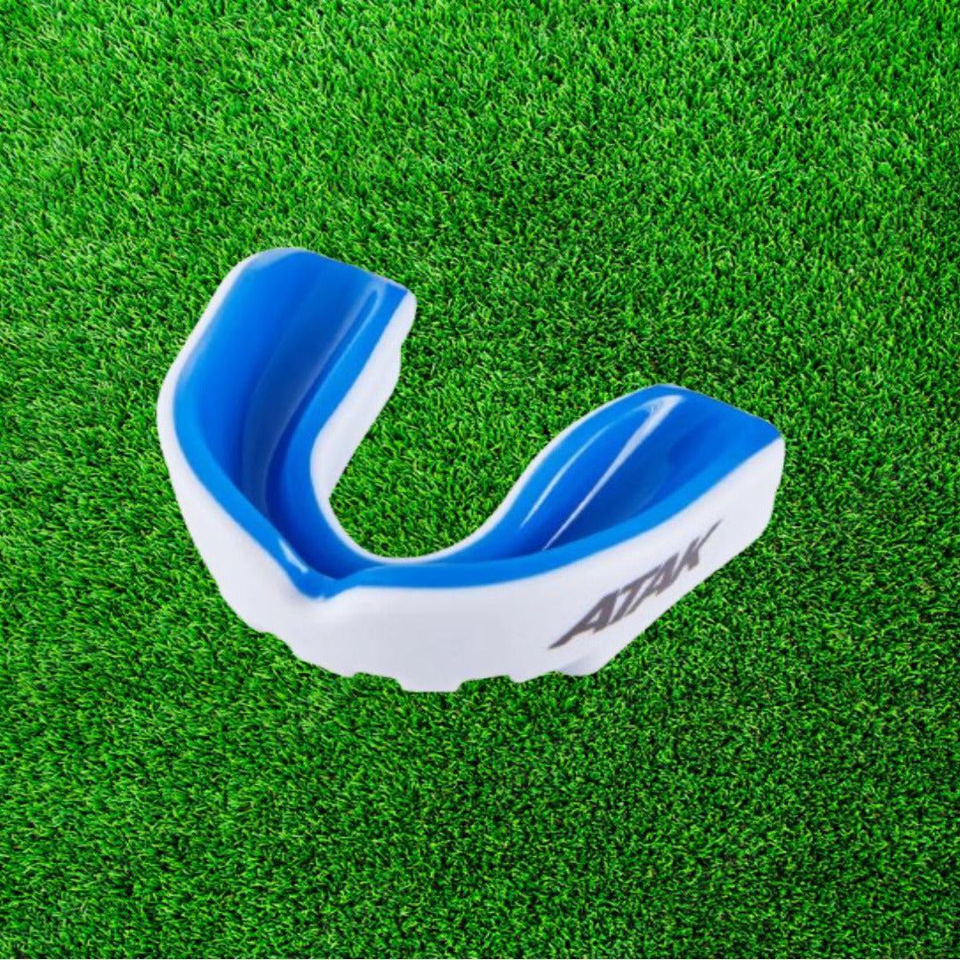 Blue and white mouthguard on a green grass background