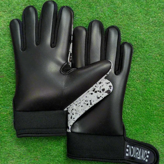 White and black Endurance Leisure gloves on a green grass background