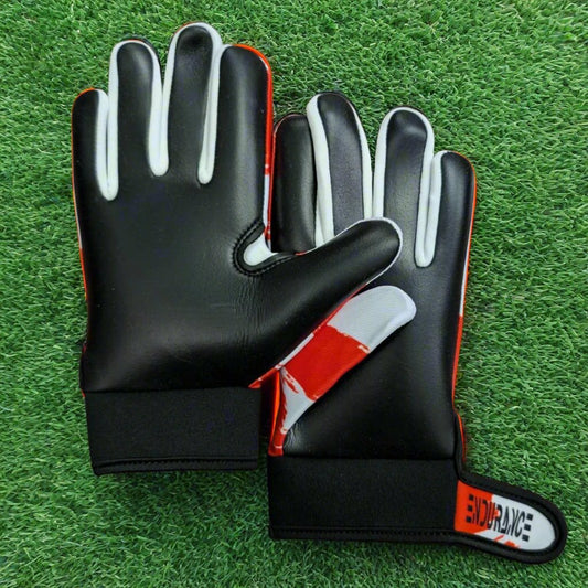 Red and white Endurance Leisure gloves on a green grass background