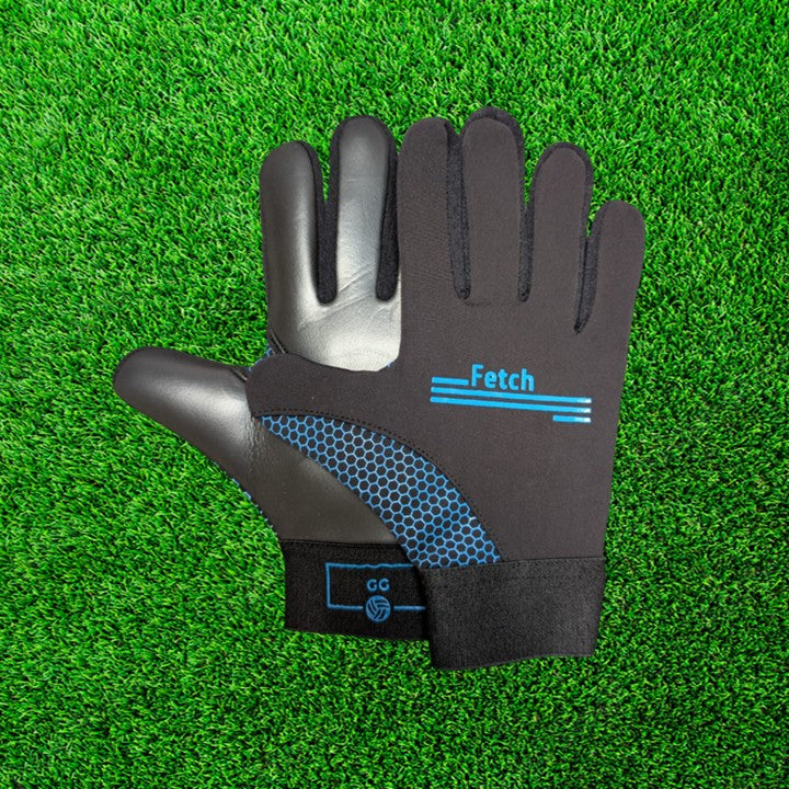 Black and blue gloves with blue accents on a green grass background
