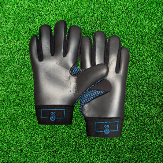 Black and blue gloves with blue accents on a green grass background