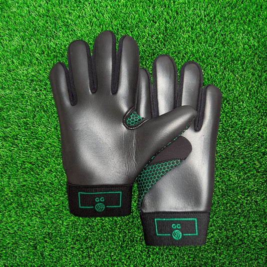 Black and green gloves with green accents on a green grass background