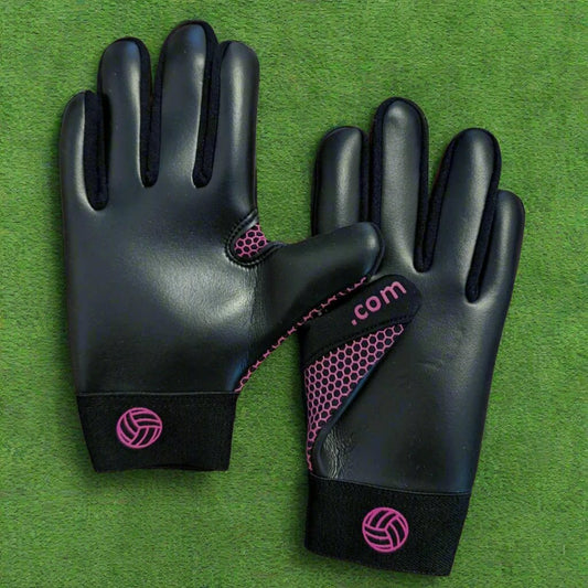 Black and pink Fetch V1 gloves on a green grass background