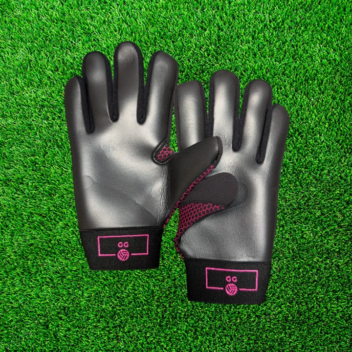 Black and pink gloves with pink accents on a green grass background