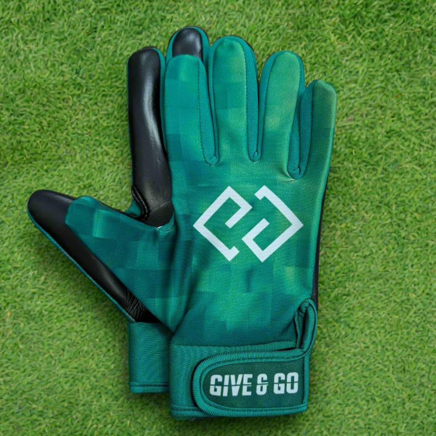 Green and white GiveAndGo gloves on a green grass background
