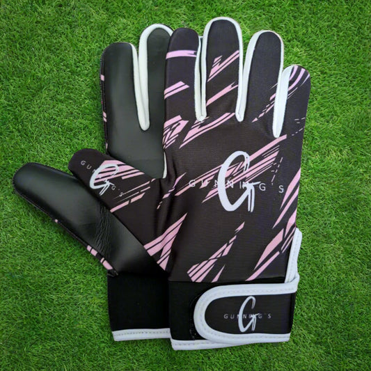 Black and pink Gunning's gloves on a green grass background