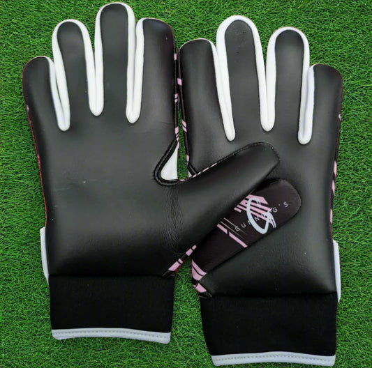 Black and pink Gunning's gloves on a green grass background