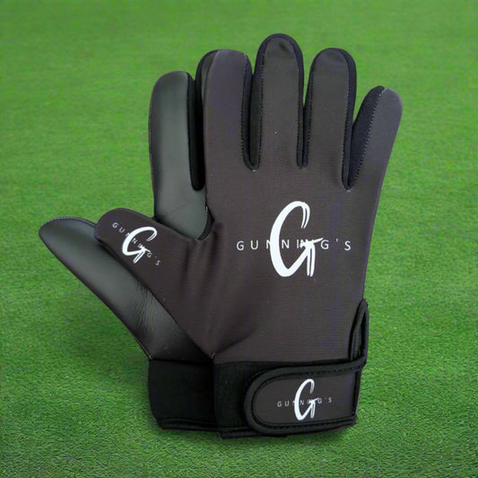 Black and white Gunning's gloves on a green grass background