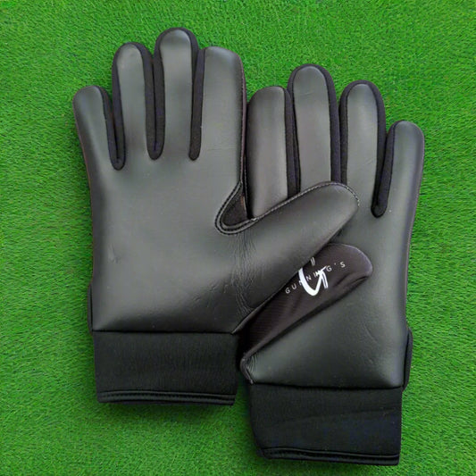 Black and white Gunning's gloves on a green grass background