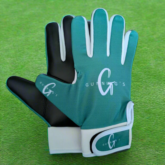 Green and white Gunning's gloves on a green grass background