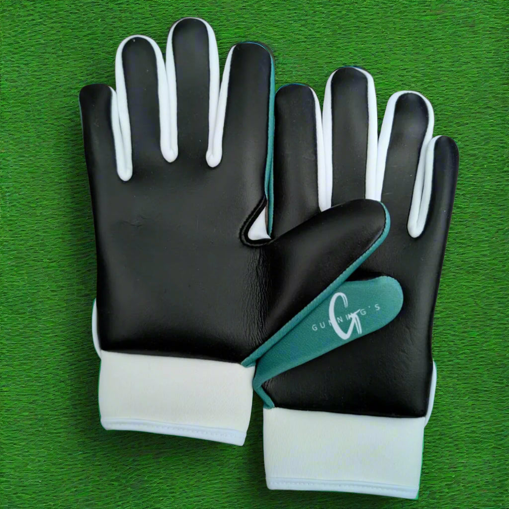 Green and white Gunning's gloves on a green grass background