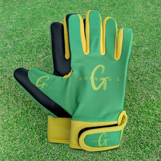 Green and yellow Gunning's gloves on a green grass background