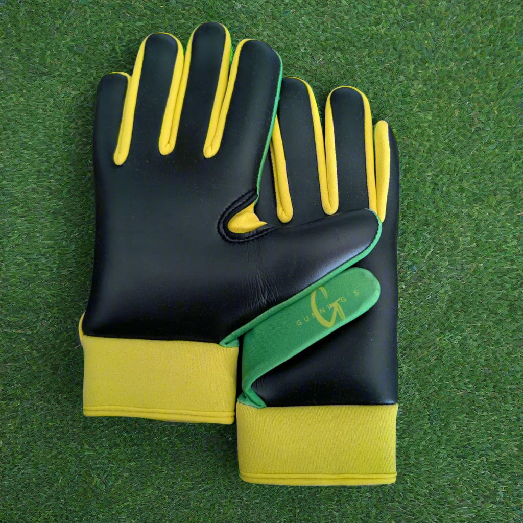 Green and yellow Gunning's gloves on a green grass background