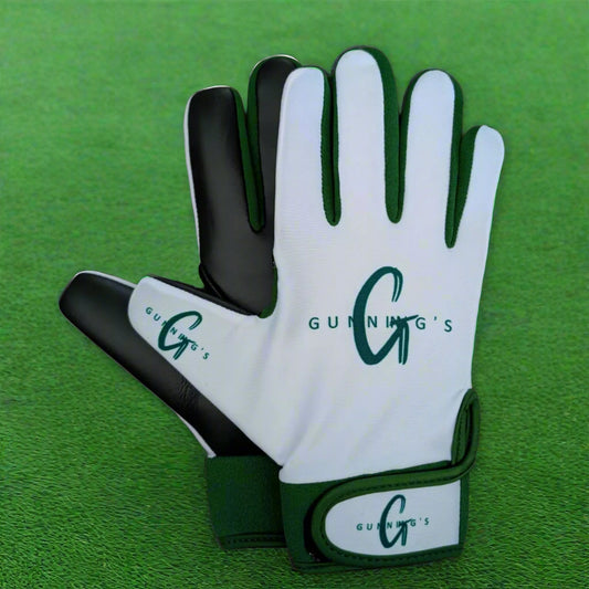White and green Gunning's gloves on a green grass background