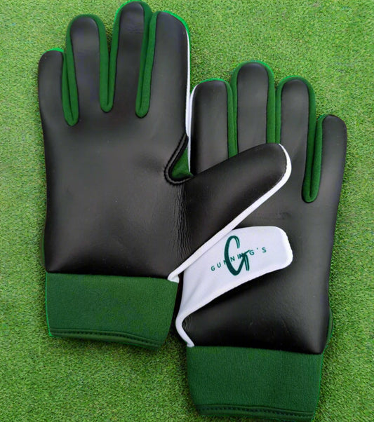 White and green Gunning's gloves on a green grass background