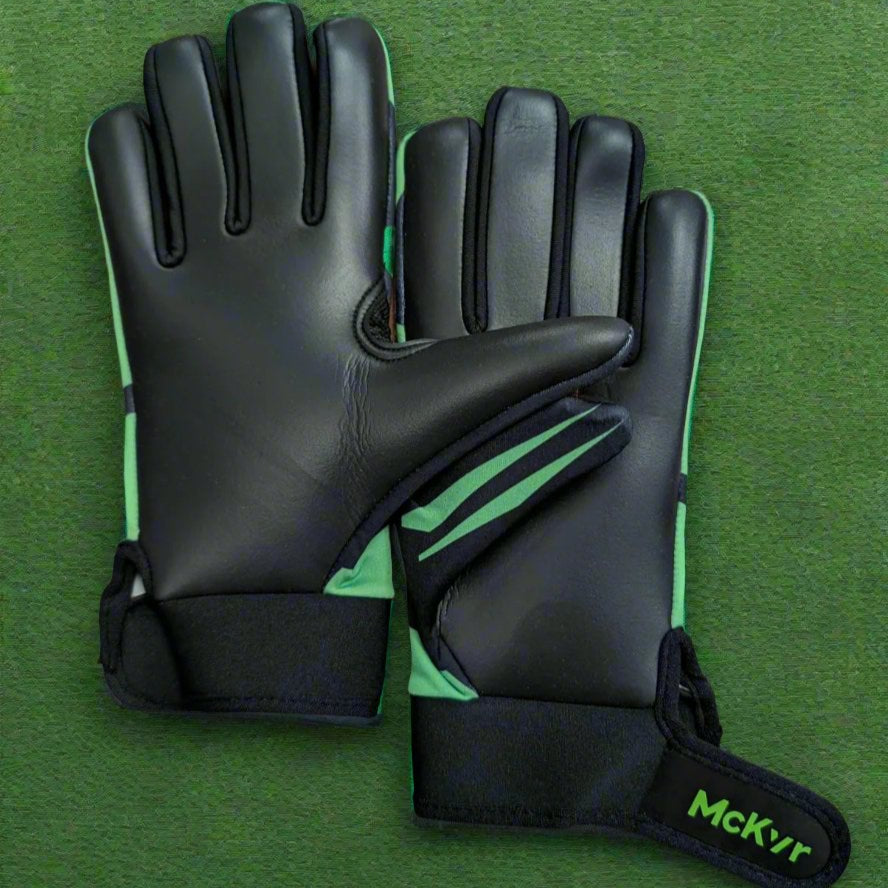Black and green McKeever gloves on a green grass background
