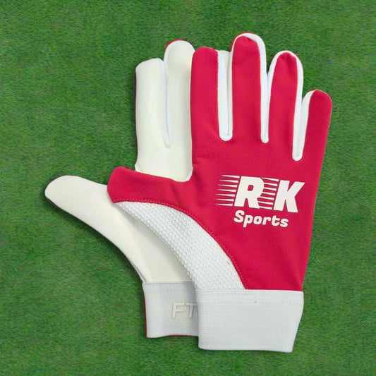 Pink and white RK sports gloves on a green grass background