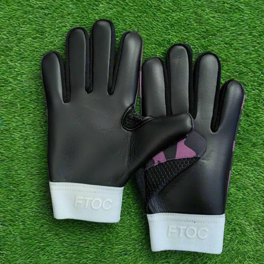 Purple and black RK sports gloves on a green grass background