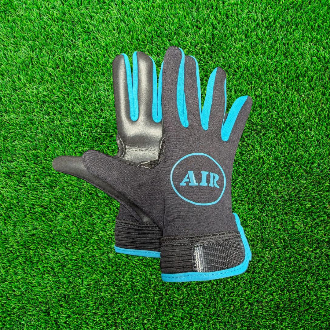 Black and blue ATAK air gloves on a green grass background