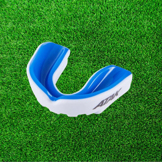 Blue and white mouthguard on a green grass background