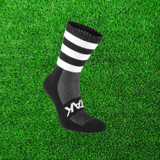 Black and white ATAK sock on a green grass background