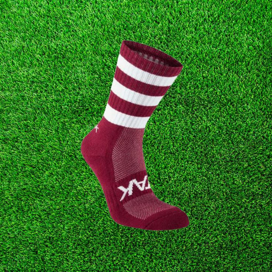 Maroon and white ATAK sock on a green grass background