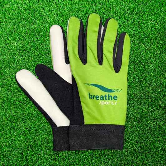 Green Breathe sports gloves on a green grass background
