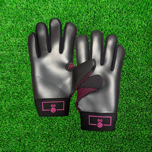 Black and pink gloves with pink accents on a green grass background
