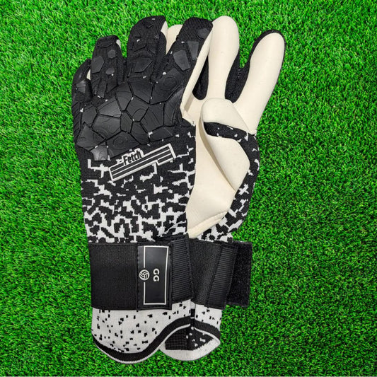 Black and white goalkeeper glove on a green grass background
