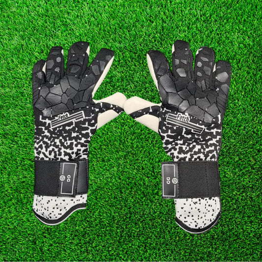 Black and white goalkeeper glove on a green grass background