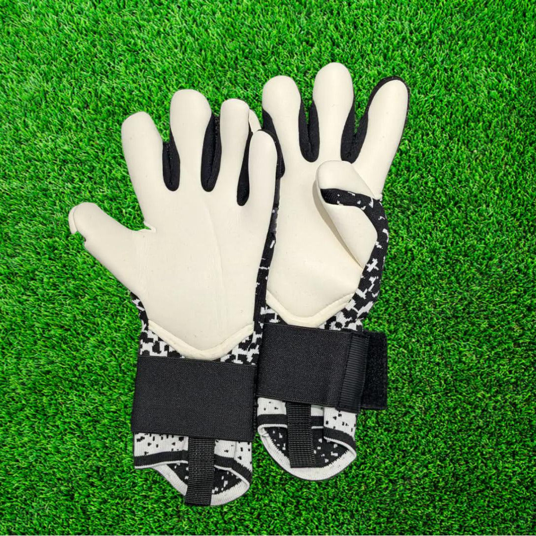 Black and white goalkeeper glove on a green grass background