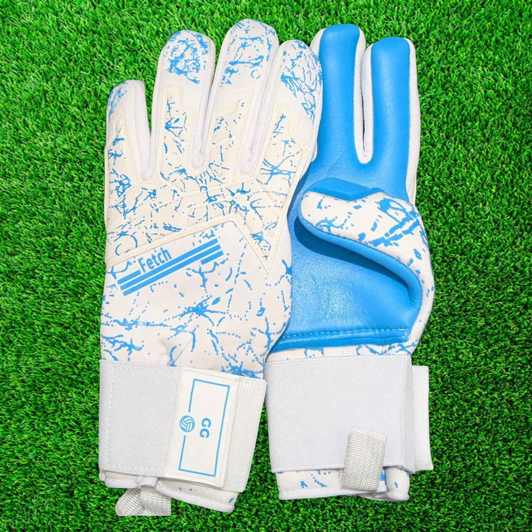 Pair of white and blue goalkeeper gloves on a green grass background