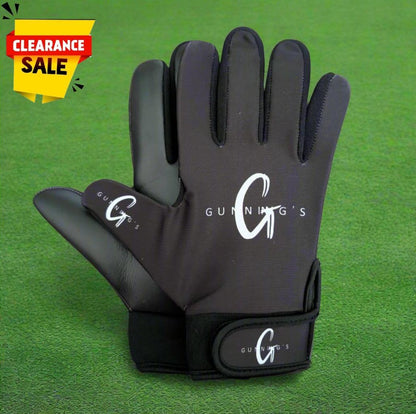 Black and white Gunning's gloves on a green grass background with a clearance sticker