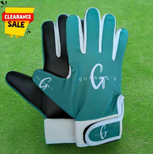 Green and white Gunning's gloves on a green grass background with a clearance sticker