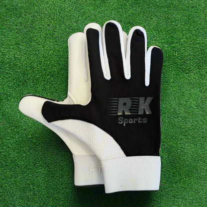 Black RK sports gloves on a green grass background