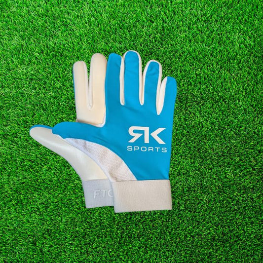 Blue and white RK sports gloves on a green grass background
