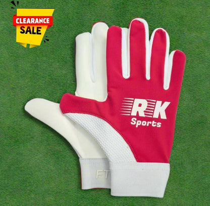 Pink RK sports gloves on a green grass background with a clearance sticker