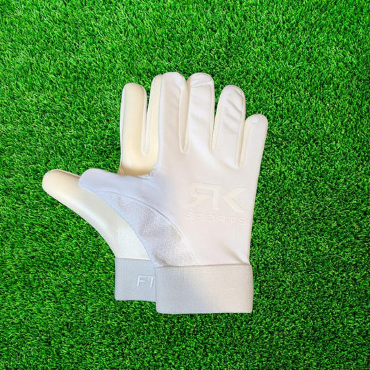 White RK sports gloves on a green grass background